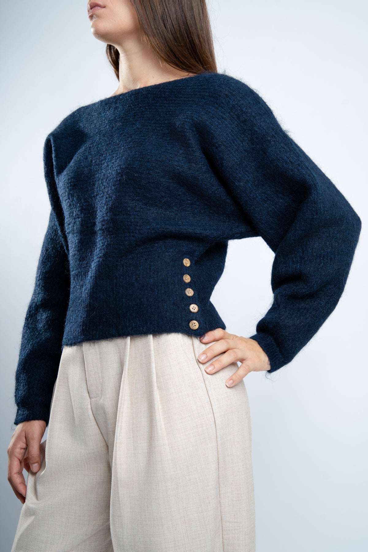 Pull en maille marine avec boutons latéraux.