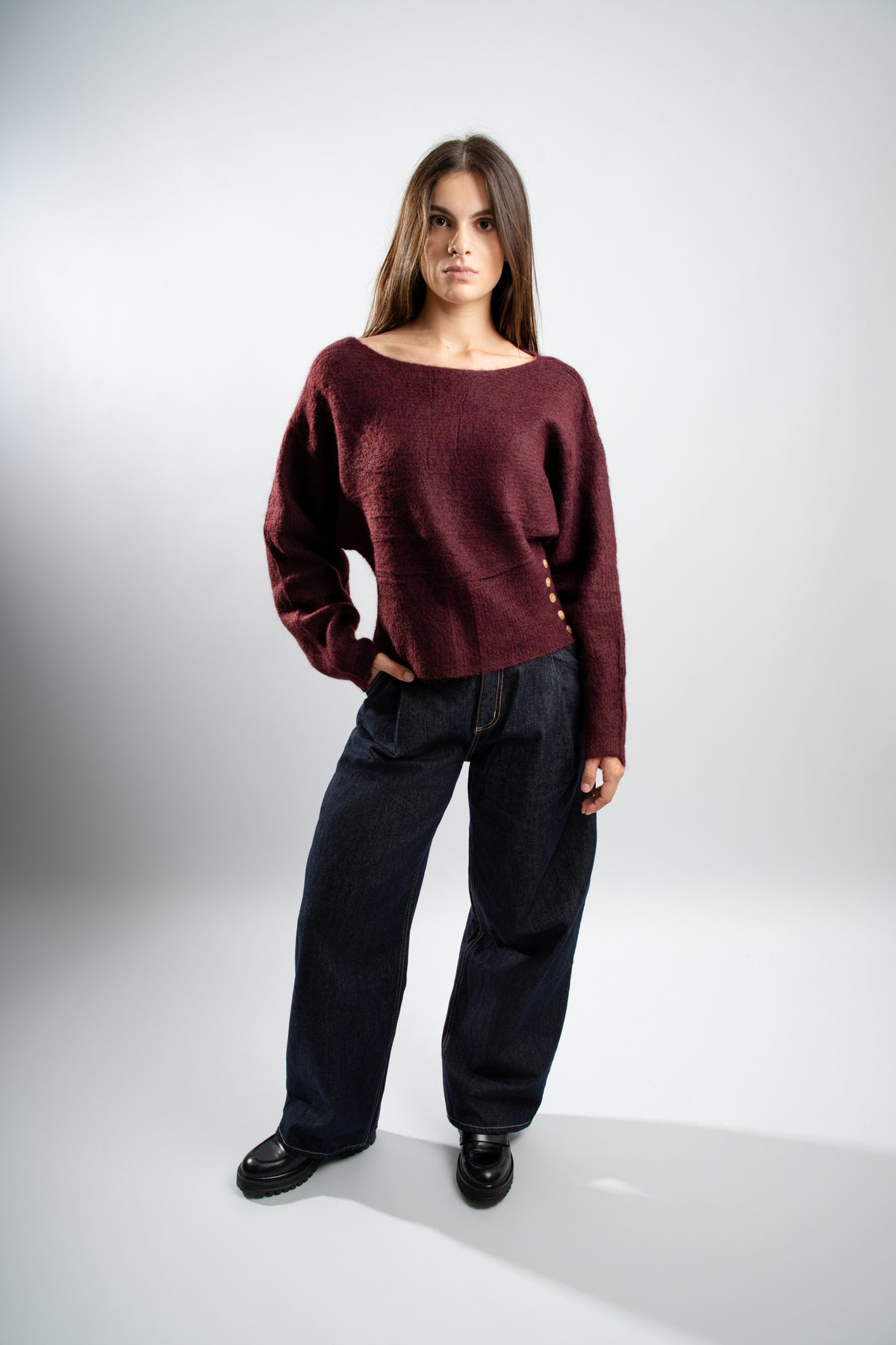 Pull en maille Bordeaux avec boutons latéraux.