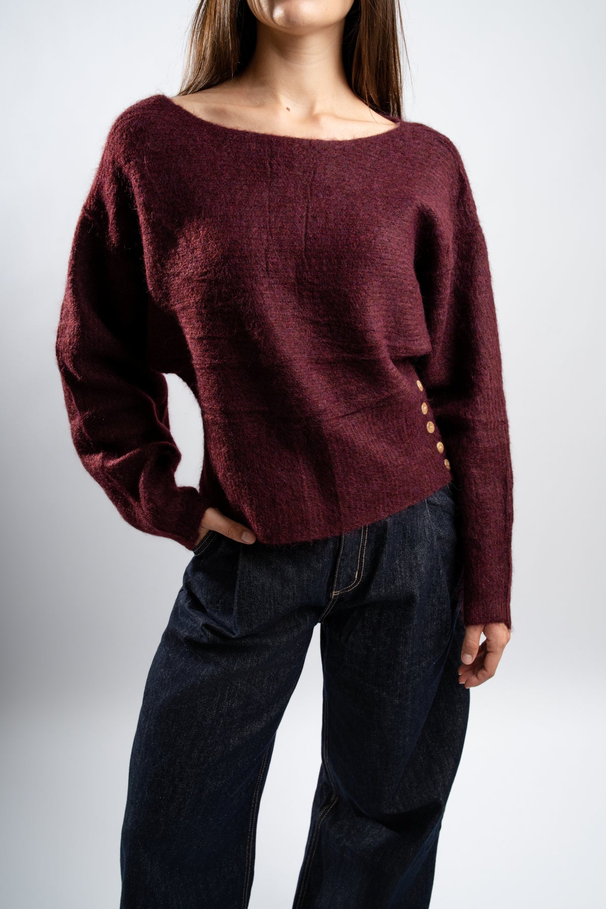 Pull en maille Bordeaux avec boutons latéraux.