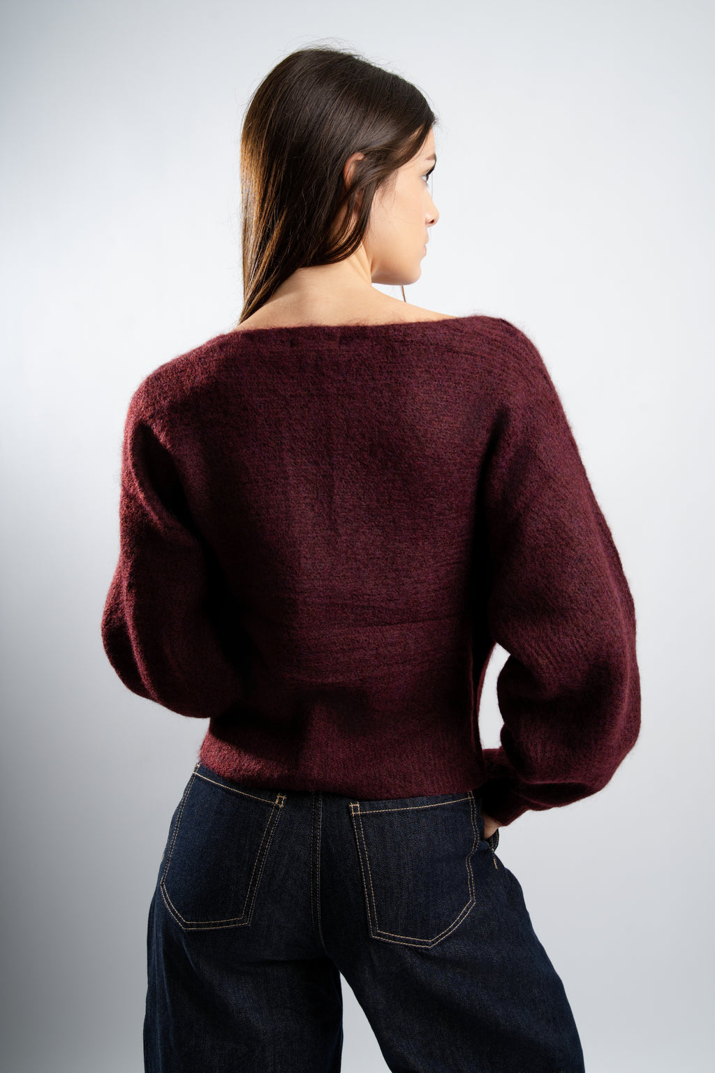 Pull en maille Bordeaux avec boutons latéraux.