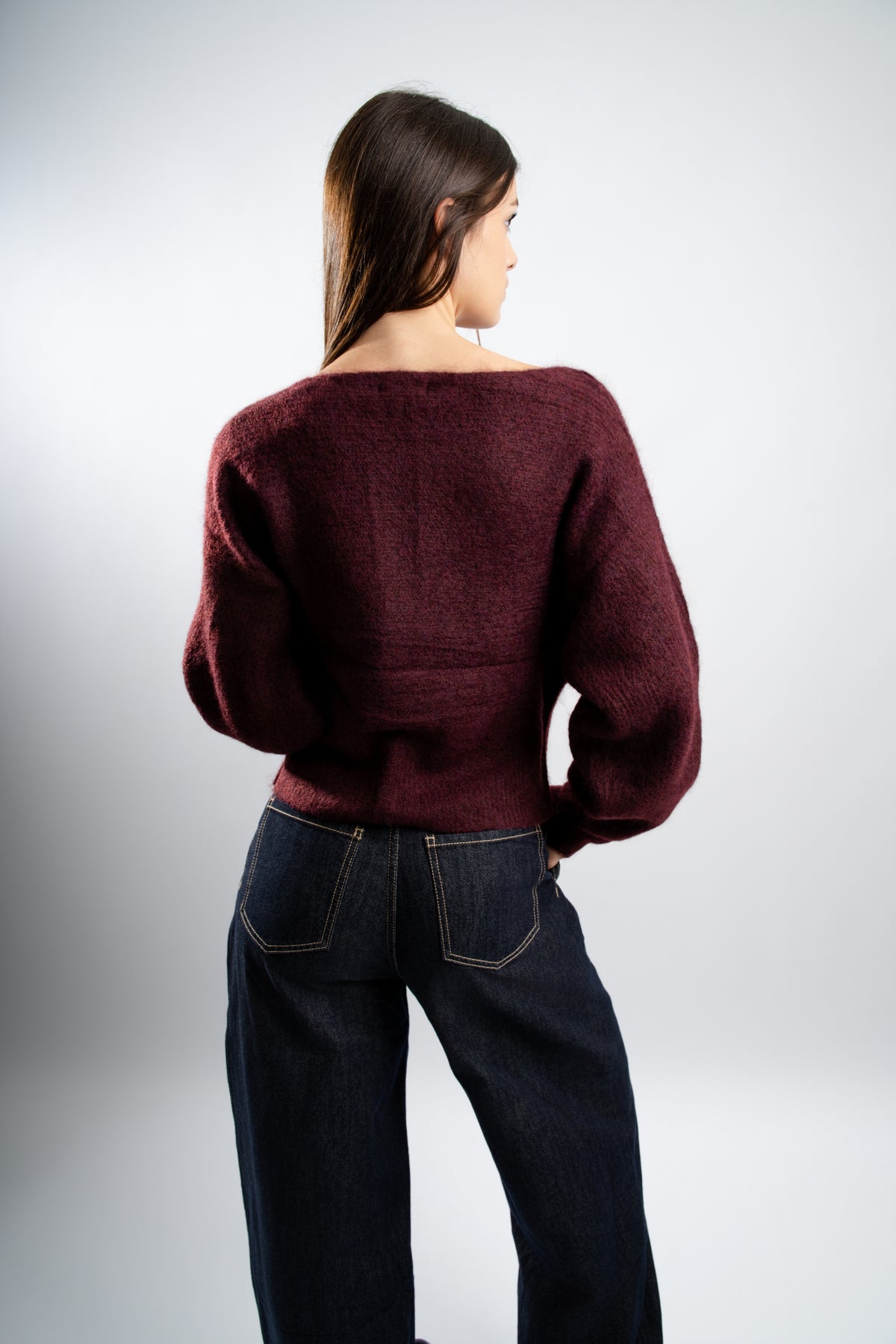 Pull en maille Bordeaux avec boutons latéraux.